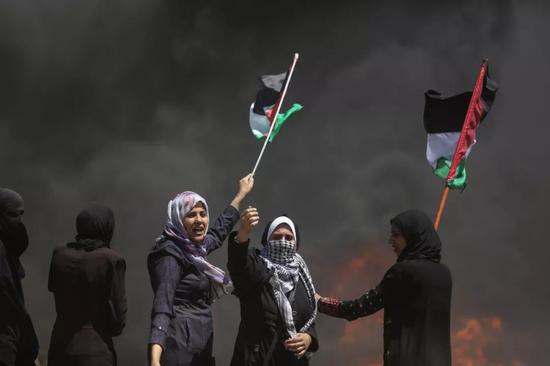  2018年5月14日，在加沙城以东的加沙地带与以色列边境，巴勒斯坦妇女参加示威活动，抗议美国驻以色列使馆当天在耶路撒冷正式开馆。新华社发（维萨姆·纳萨尔摄）