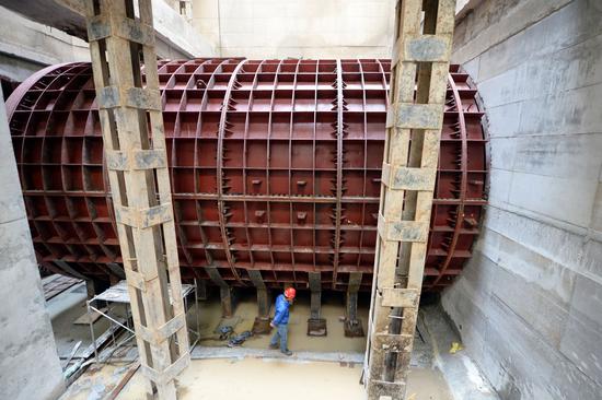  在黄河兰州段地面以下40米深处，施工人员查看地铁隧道口内部盾构机对外部钢套管的影响（新华社）