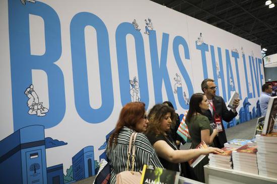 5月29日，在美国纽约举行的2019年美国书展上，参观者翻阅图书。 （新华社）