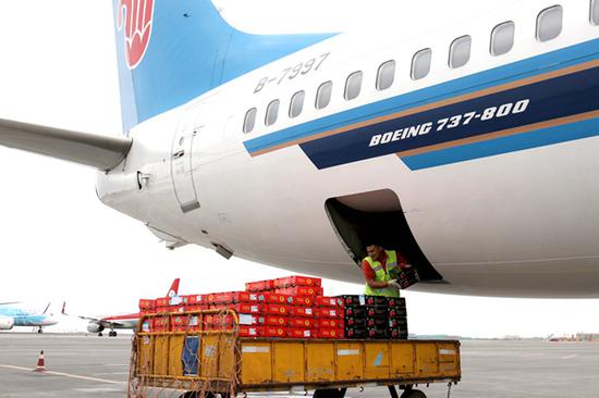 6月12日，工作人员在乌鲁木齐地窝堡国际机场卸运从吉尔吉斯斯坦进口的樱桃。新华社图