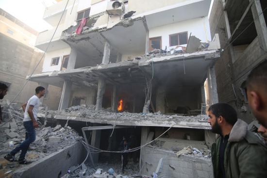 5月5日，在加沙地带拉法，巴勒斯坦人查看遭以军空袭损毁的房屋。（新华社发，哈立德·奥马尔摄）。
