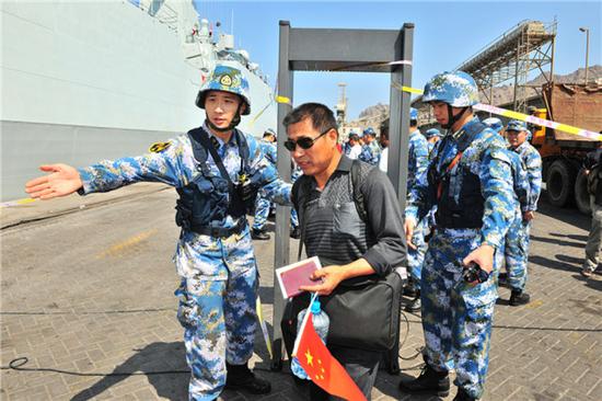 中国海军第十九批护航编队临沂舰抵达也门亚丁港,帮助准备撤离的中国同胞进行安全检查(2015年3月29日摄)。新华社发(熊利兵 摄)