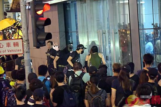 杨逸朗（绿色背心）在6月26日晚疑尝试冲击警总玻璃门。来源：香港文汇网（资料图片）