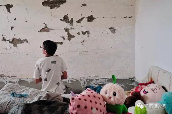 ▲图为路尾社区村民杨博坐在他原来的房间里，如今这个房子因墙体开裂无法居住。新京报记者 郑新洽 摄