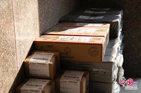 门口,消费者网上订购的农产品打包装箱,摆放整齐,等候快递车上门提货