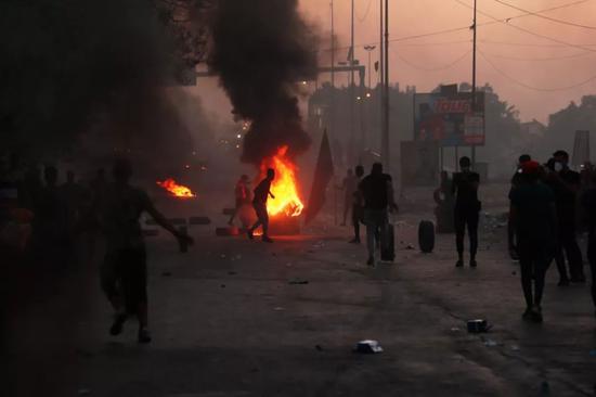 10月5日，在伊拉克巴格达，示威者在街头燃烧轮胎。新华社/法新