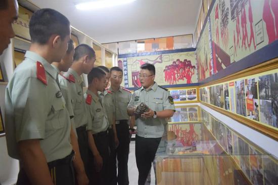 28发消灭23个敌人 一面面鲜红的战旗在战火洗礼中傲然挺立 △向新兵讲述历史。