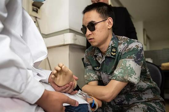 2019年10月23日，重庆西南医院康复楼，杜富国尝试将智能手穿戴到胳膊上。新京报记者 李凯祥 摄