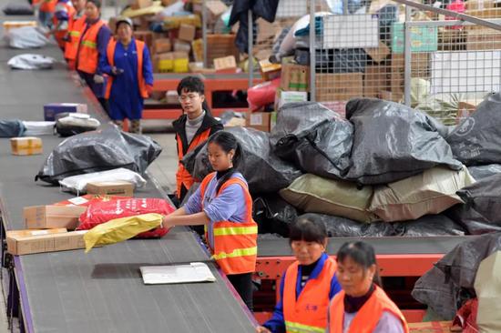 2018年11月14日，南昌一快递转运中心，工作人员在流水线上分拣快递包裹。新华社记者彭昭之摄