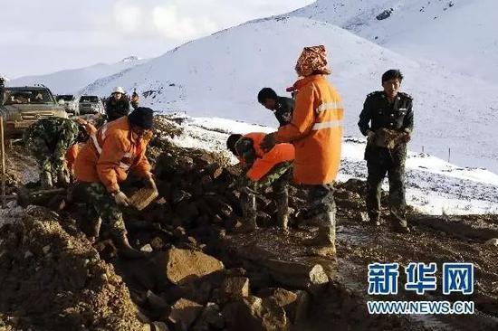  ▲川藏公路矮拉山段公路养护人员在用石块填充路面