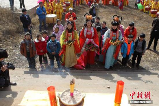 资料图：民众在“春姑娘”的带领下祭拜灶神，当日是农历腊月二十三，中国传统“小年”（中新社发 王中举 摄）