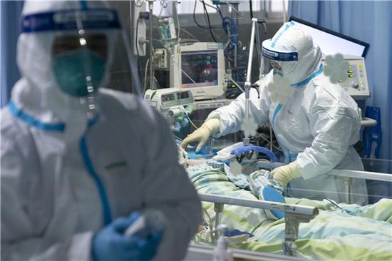 1月24日，在武汉大学中南医院重症隔离病房，医护人员为病人治疗。新华社记者 熊琦 摄