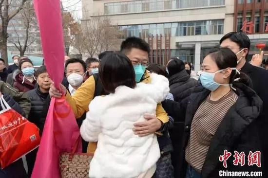 山西省抗击新型冠状肺炎紧急医疗队队员与家人拥抱告别. 胡静 摄