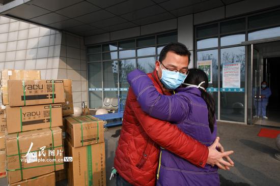 2月2日，在江苏省连云港市赣榆区人民医院，驰援武汉医疗护理队队员与丈夫拥抱告别。司伟/人民图片