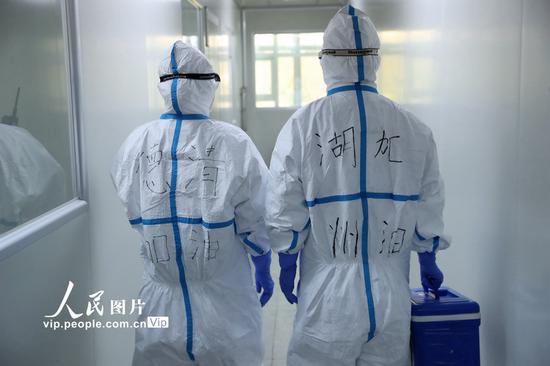 2020年1月31日，在浙江省湖州市德清县疾控中心，技术人员准备进入新型冠状病毒感染肺炎病原体检测实验室开展检测工作。谢尚国/人民图片