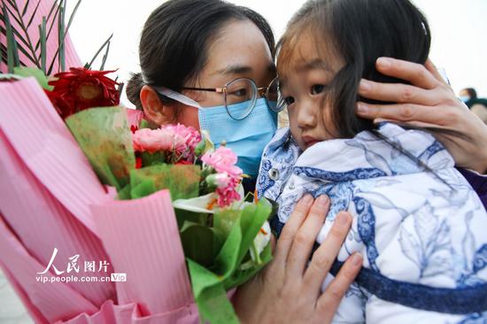 2月2日，在江苏省连云港市赣榆区人民医院，驰援武汉医疗护理队队员王洁（左）与女儿拥抱告别。司伟/人民图片