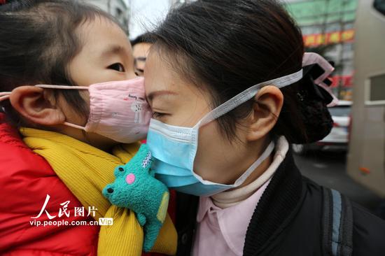2020年1月28日，3岁的杨舒培小朋友依依不舍亲吻妈妈的额头。兰锋/人民图片
