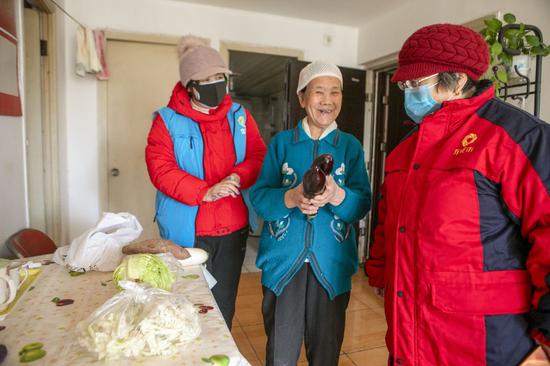  社区志愿者为居民送菜上门（资料图）