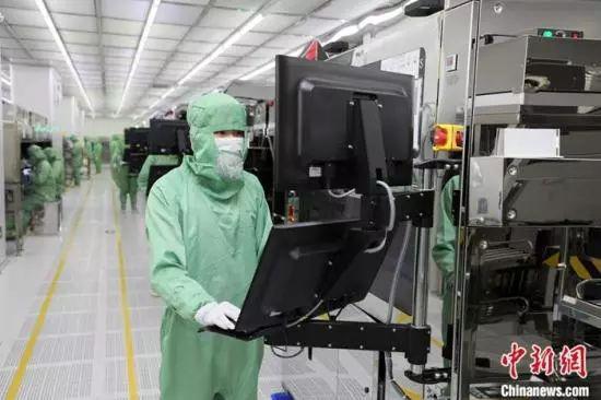  2月18日，广州市黄埔区的外资企业厂区内，工人们身着防护设备，全副武装复工。中新社记者 王华 摄