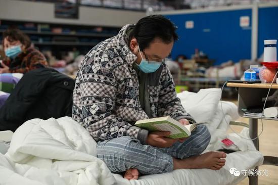 2月21日，武汉市洪山体育馆方舱医院A区内，一名患者在看《安妮日记》。中青报·中青网见习记者 鲁冲/摄