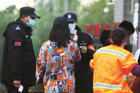 2月14日,江西南昌的一个小区,市民在进入小区时出示自己的身份证。图/中新