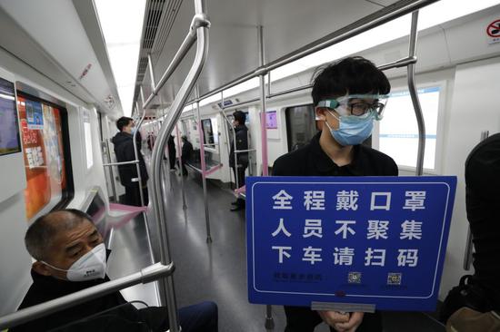 3月28日，武汉轨道交通部分线路恢复运营。这是一名“随车安全员”在武汉地铁2号线车厢里巡视。新华社记者 沈伯韩 摄