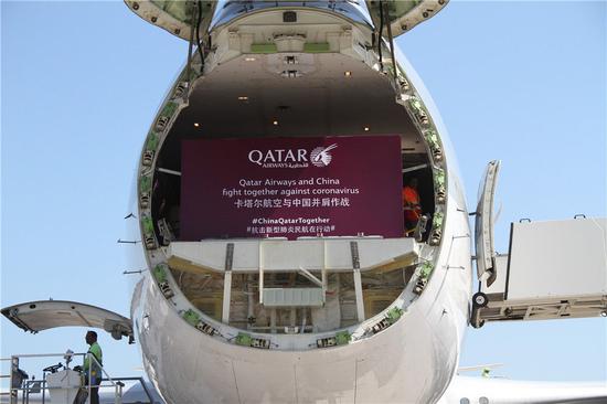 2月21日，在卡塔尔多哈的哈马德国际货运机场，卡塔尔航空公司的货机在装载运往中国的抗疫物资。新华社发（尼库摄）