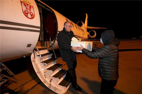3月15日，在塞尔维亚首都贝尔格莱德机场，工作人员搬运装载着新冠病毒检测试剂盒的箱子。塞尔维亚政府16日说，由中国捐赠的首批1000个新冠病毒检测试剂盒已于15日夜送达贝尔格莱德，帮助塞尔维亚抗击新冠肺炎疫情。新华社发（塞尔维亚政府供图）