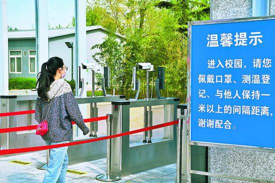 一零一中学已在校门口加装测温设备,贴出一米线.本报记者 邓伟 摄