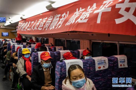  在昆明南站，外出务工人员在 “滇粤劳务协作返岗专列”上等候发车（2月18日摄）。新华社记者 胡超 摄
