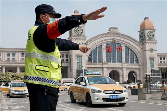4月8日，管理人员在汉口火车站前指挥出租汽车入位。新华社记者 王毓国 摄