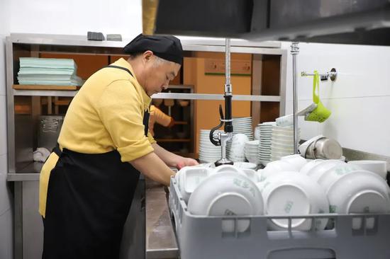 每年春节营运高峰期,束从轩都在餐厅后厨帮忙刷碗.