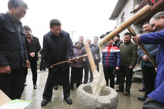 △ 　　2016年2月2日，习近平在江西井冈山市茅坪乡神山村同村民一起打糍粑。