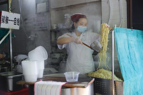武汉市粮道街的家阳“赵师傅”天天红油热干面店厨师在制作热干面（4月22日摄）。新华社记者 沈伯韩 摄