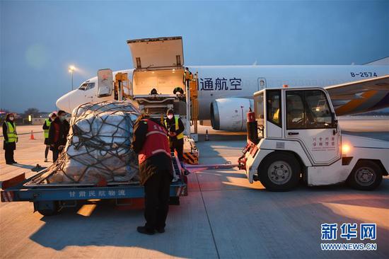 2月19日，在兰州中川国际机场，机场货运工作人员往飞机上装运运往武汉的防疫物资。 新华社记者 范培珅 摄