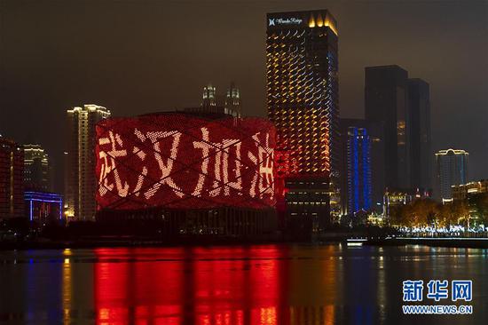 1月24日是除夕，湖北省武汉市汉秀剧场的外墙打出“武汉加油”字样。 新华社记者 熊琦 摄