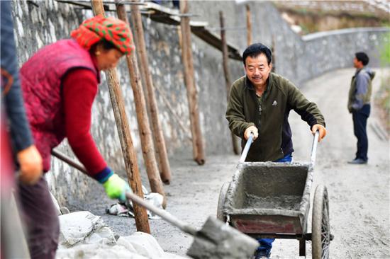 甘肃省甘南藏族自治州舟曲县果耶镇勒阿村驻村第一书记张金利（右）和村民一起修建入村道路的护坡（2020年4月22日摄）。新华社记者 陈斌 摄