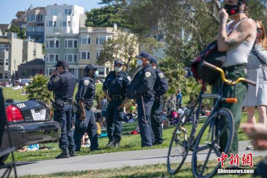 当地时间5月24日，美国旧金山警员在多洛雷斯公园执勤。很多美国人选择在户外庆祝将士阵亡纪念日长周末，公共卫生官员担忧，大型聚会可能导致疫情再次暴发。 中新社记者 刘关关 摄