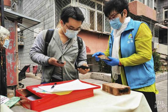 △疫情防控常态化背景下，北京市民出入社区依然需出示出入证、测体温等。