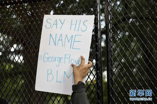 ▲6月2日，一名示威者手举写有乔治·弗洛伊德的名字的标语在美国华盛顿白宫前抗议。新华社发（沈霆 摄）
