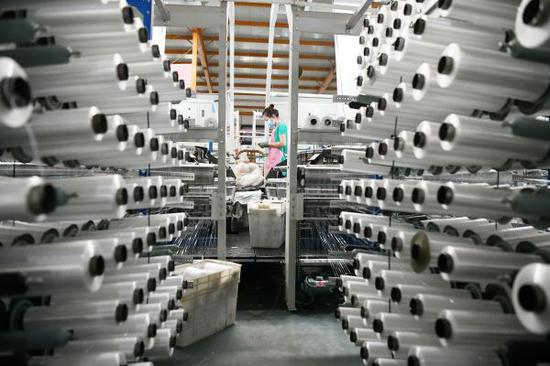 图说: 5月21日,工人在黑龙江省南洋塑料制品有限公司生产车间作业。 新华社记者 王建威 摄