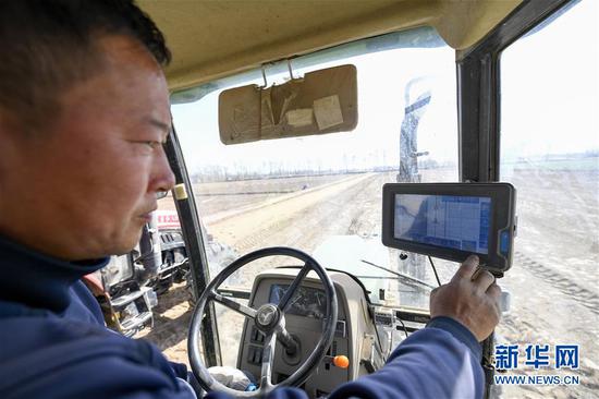 在位于宁夏吴忠市利通区金积镇塔湾村的智慧农业科技示范区，农机手在播种前调试自动驾驶拖拉机（2020年4月9日摄）。新华社记者 冯开华 摄