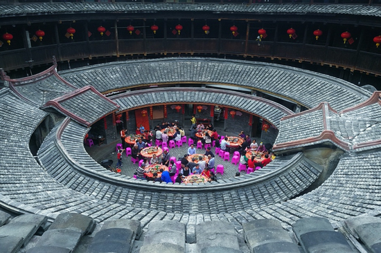 2019年2月15日（正月十一），福建省龙岩市永定土楼环聚楼里的居民正聚集在一起吃团圆饭，每年祭祖完后，族人们都会在楼里摆上宴席。图源：视觉中国