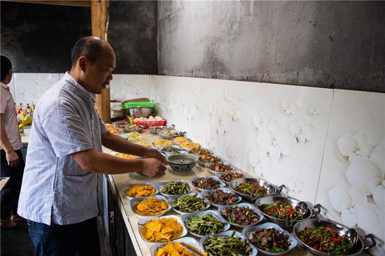 在湘西十八洞村，杨正邦在自家开的饭店厨房里帮忙（6月30日摄）。新华社记者 陈思汗 摄