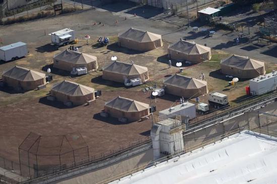 （图说：圣昆廷监狱后院用于安置感染新冠囚犯的帐篷。）