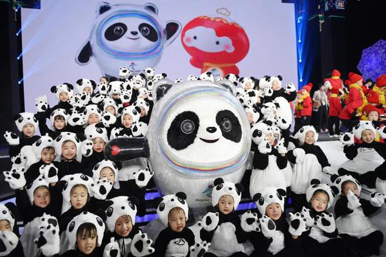 2019年9月，北京，小朋友与冬奥会吉祥物“冰墩墩”合影。（新华社记者鞠焕宗 摄）