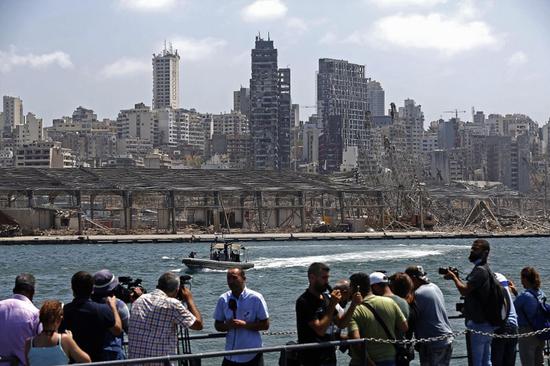 2020年8月8日，媒体记者在被炸毁的黎巴嫩贝鲁特港口区采访。贝鲁特港口区4日傍晚发生剧烈爆炸，迄今爆炸已造成158人死亡、6000多人受伤，另有数十人下落不明。爆炸还造成约30万民众无家可归。 新华社发（比拉尔·贾维希 摄）