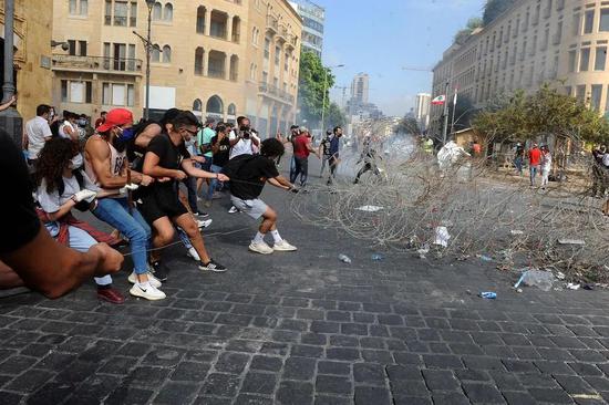  示威者拉开铁丝网试图冲入黎巴嫩议会大楼（图源：新华社）