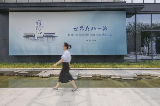 一名行人走过浙江嘉善祥符荡创新中心的标牌（5月27日摄）。新华社记者 张玉薇 摄
