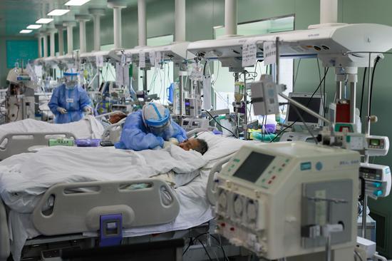 4月24日，在位于武汉的华中科技大学同济医学院附属协和医院西院，医务人员在护理核酸检测结果转阴的新冠肺炎病人。新华社记者 沈伯韩 摄
